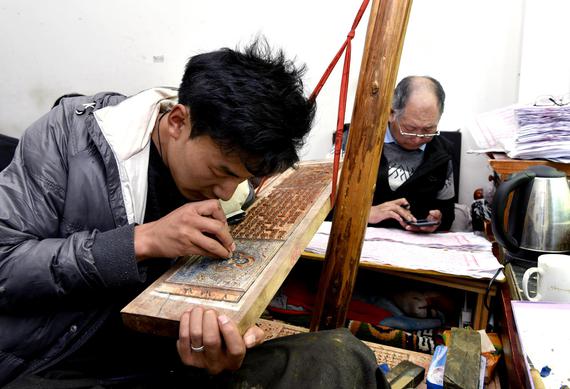 A Tibetan artisan carves an illustration into a printing block for a Tibetan Buddhist sutra at Xuedui Bai Vocational Technical School, Lhasa, Xizang Autonomous Region, May 8, 2023. (Photo by CNS)