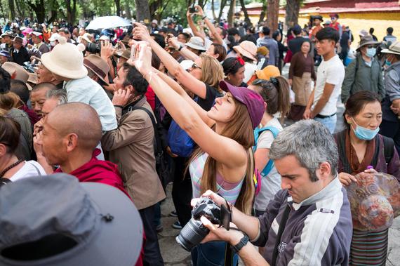 Overseas tourists watch a Tibetan Opera performance in Lhasa, August 12, 2018
(Photo by CNS)