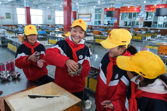 Sixth grader Nyima Lhadron (second from left) makes tsampa, a staple food made from 
barley flour, with classmates at Baingoin County Sinopec Primary School, Nagqu, Xizang 
Autonomous Region, October 13, 2023. The school has more than 1,300 students and 
provides boarding for a majority of its students in grades 4 to 6. (Photo by CNS)