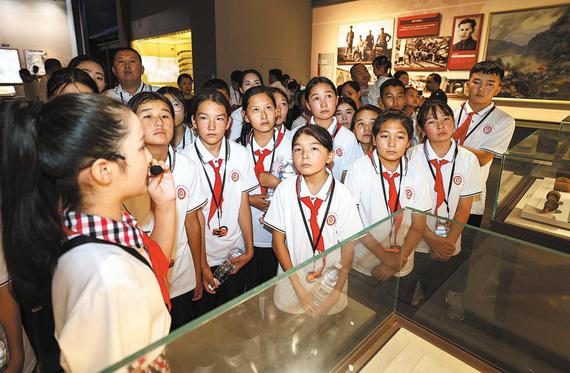 A guide introduces exhibits to the students at the Hundred Regiments Offensive Memorial Hall on Aug 9. (XUE ERWEI/FOR CHINA DAILY)