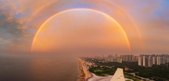 Stunning rainbow meets rosy clouds over sky in east China