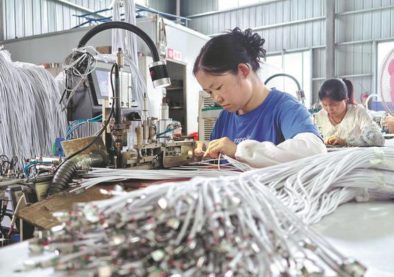 Workers manufacture data cables at a production workshop of an electronics enterprise in Liuzhou, Guangxi Zhuang autonomous region, on Aug 20. TAN KAIXING/FOR CHINA DAILY