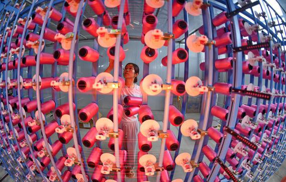worker handles products at the Shu Brocade Workshop of the Chengdu Shu Brocade Research Institute, a private enterprise in Chengdu, Sichuan province. (LI XIANGYU / FOR CHINA DAILY)