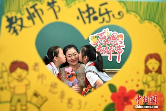 Students from Shuguang Primary School in Handan City, Hebei Province, presents handmade crafts to their teacher and kiss her to express their best wishes. (Photo: VCG) Students from Shuguang Primary School in Handan City, Hebei Province, presents handmade crafts to their teacher and kiss her to express their best wishes. (Photo: VCG)