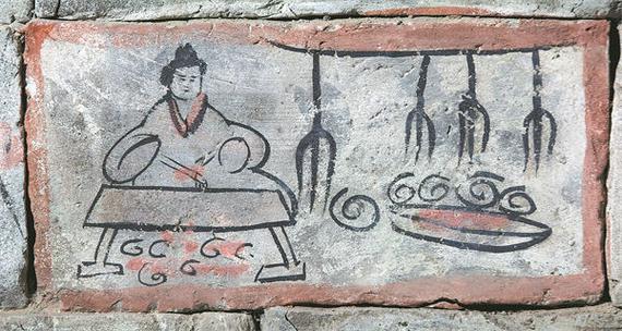 A mural brick found in the Wei and Jin Dynasty Tombs in Jiayuguan, Gansu province, depicts a chef roasting meat on fire before serving it to guests at a banquet. [Photo provided to China Daily]