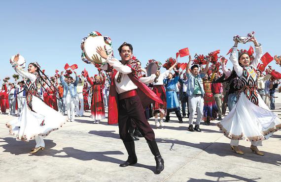 People from various ethnic groups stage a performance to welcome Xi and the central delegation at Urumqi Tianshan International Airport on Tuesday. FENG YONGBIN/CHINA DAILY