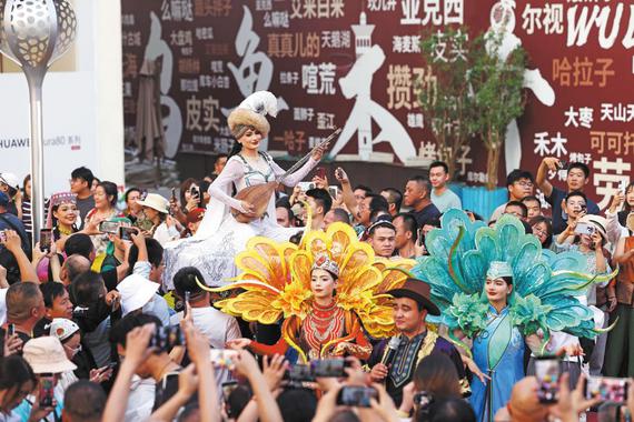 Performers dressed in traditional ethnic costumes perform at the Xinjiang International Grand Bazaar in Urumqi, Northwest China's Xinjiang Uygur autonomous region, on Sept 8. The word "bazaar" in the Uygur language means "market" and "trade place". (ZHU XINGXIN/CHINA DAILY)