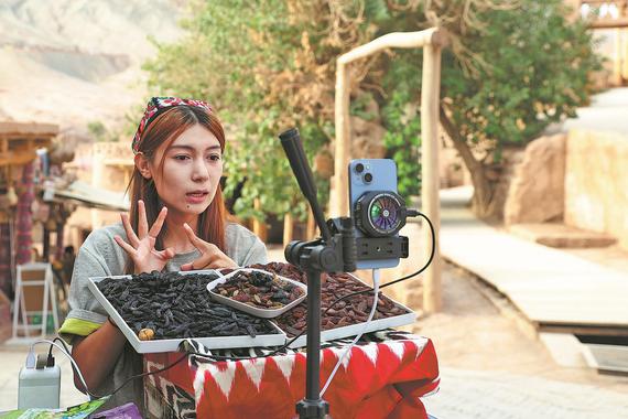 A vendor livestreams to promote her products at Tuyugou Cultural Tourism Town. (WANG ZIRU/CHINA NEWS SERVICE) A vendor livestreams to promote her products at Tuyugou Cultural Tourism Town. (WANG ZIRU/CHINA NEWS SERVICE)