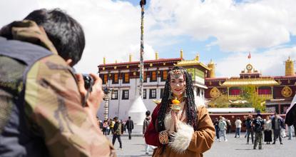 Global tourists dressed in Tibetan attire experience local culture in Lhasa