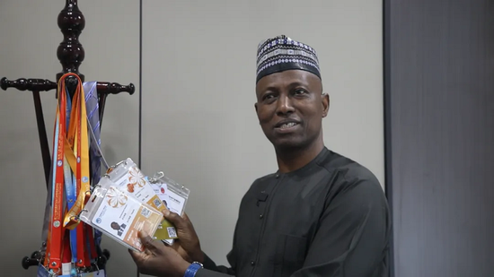Hassan Mohammed showcases his exhibitor passes from previous CIIEs. [Photo/CIIE Bureau]