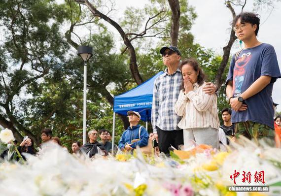 Hong Kong residents visit the site of the Tai Po Hongfu Court fire, offering flowers and paying their respects to the victims. (Photo: China News Service / Hou Yu)
