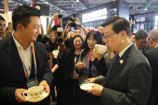 Chief Executive of the Hong Kong Special Administrative Region John Lee (right) tried Hong Kong-style milk tea at CIIE.