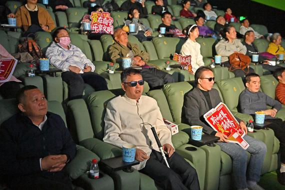 Visually-impaired people, together with their family members and volunteers, enjoy a movie at a cinema in Nanning, south China's Guangxi Zhuang Autonomous Region, Dec. 3, 2025. (Xinhua/Zhou Hua)