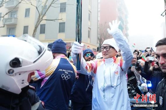 Chinese double-Olympics volunteer Zhang Wenquan holds a torch as the flame arrives in Milan, Italy, on Feb. 5, 2026. (Photo: China News Service/Jiang Qiming)