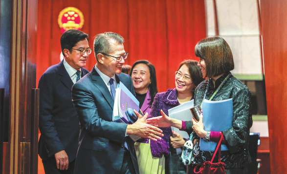 Hong Kong Financial Secretary Paul Chan Mo-po (second from left) greets lawmakers after delivering the 2026-27 Budget address on Wednesday. (ANDY CHONG/CHINA DAILY)