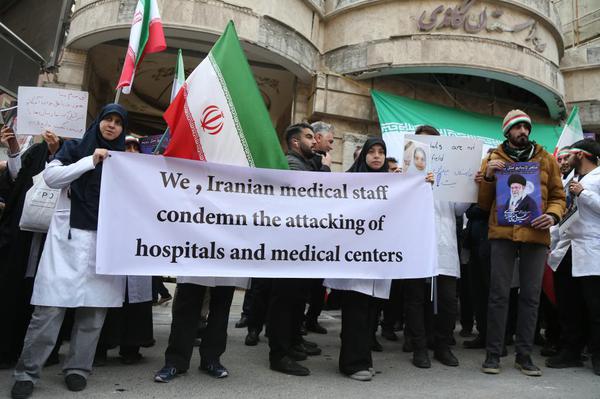 Medical workers participate in a rally in front of a hospital damaged in a U.S.-Israeli strike, in Tehran, Iran, March 7, 2026.  (Xinhua/Shadati)