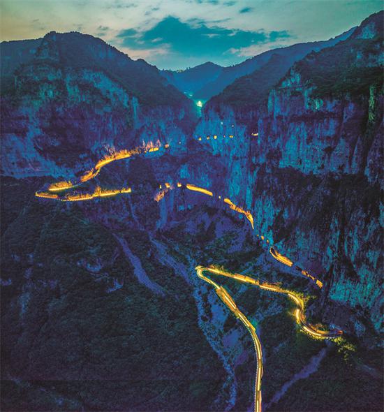The cliffside highway leading to Xiyagou village is illuminated. (WU YANFEI/FOR CHINA DAILY)