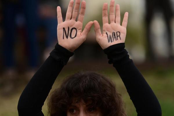 A demonstrator raises hands painted with "No War" slogan during a rally to protest against U.S.-Israeli attacks on Iran and demand an end to all acts of war in Tel Aviv, Israel, March 14, 2026. (Tomer Neuberg/JINI via Xinhua)