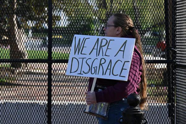 A demonstrator holds a placard in front of the White House in Washington, D.C., the United States, on April 7, 2026. (Xinhua/Li Rui)