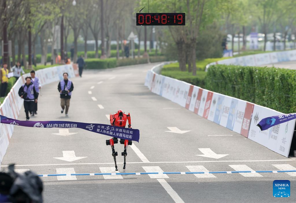 Humanoid robot "Flash" of Pofengshandian Team in the remote-controlled category crosses the finish line during the Beijing E-Town half-marathon and humanoid robots half-marathon in the Beijing Economic-Technological Development Area in southeast Beijing, China, April 19, 2026. (Xinhua/Zhang Chenlin)
