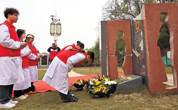 People lay flowers in front of an organ donation memorial monument as a sign of respect for the dedication of donors in Loudi, Hunan province, on March 31, 2025. (Photo by Guo Guoquan/For China Daily)