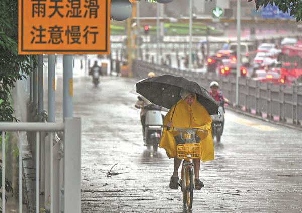 Residents make their way through rain-soaked streets in Guangzhou, Guangdong province, on Monday. Heavy to torrential rainfall, thunderstorms and strong gusts of wind affected parts of the city as severe convective weather moved through the region. (CHEN JIMIN/CHINA NEWS SERVICE）