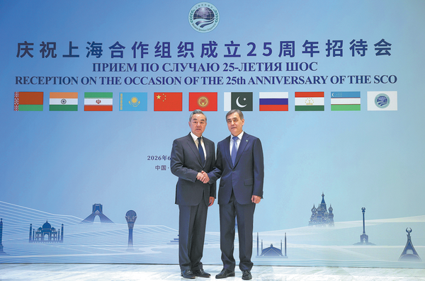 Foreign Minister Wang Yi meets with Shanghai Cooperation Organization Secretary-General Nurlan Yermekbayev on Monday during a reception in Beijing to mark the 25th anniversary of the founding of the SCO. WANG ZHUANGFEI/CHINA DAILY