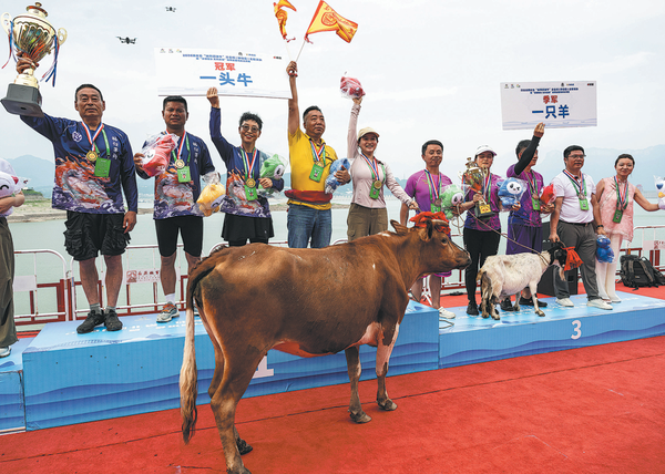 Winning team members pose with their awards at a traditional wooden dragon boat race in Zigui, Hubei province, on Saturday. The champion, runner-up and third-place teams were awarded a cow, a pig and a goat, respectively — prizes symbolizing good fortune. (ZHENG JIAYU/FOR CHINA DAILY)
