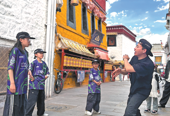 Dechung (right), co-founder of the We Did Dance studio, leads children in practicing street dance on June 5 in Lhasa, the capital of the Xizang autonomous region. (PALDEN NYIMA/CHINA DAILY)