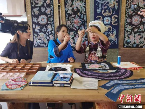 Members of the Wonders of the Mainland TV crew from Taiwan Province film the making of Shui horse tail embroidery in Sandu Shui Autonomous County, Guizhou Province, on May 21, 2024. (Photo: China News Service/Zhang Hongyan)