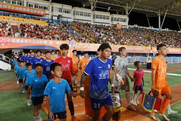 Football team members from Kinmen and Xiamen enter the court during the Fujian Football City League on July 5, 2026. (Xinhua photo)