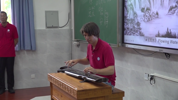 American instructor Dallas performs the traditional piece "Flowing Water" during the class. (Screenshot 
 from CNS Video)