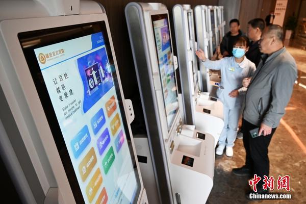 A medical worker at Xiong'an Xuanwu Hospital instructs citizens on how to use self-service terminals. (File photo: China News Service)
