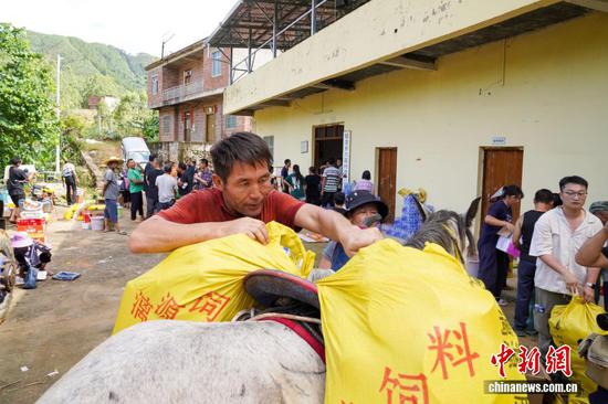 The couple transport relief supplies on horseback. (Photo: China News Service)