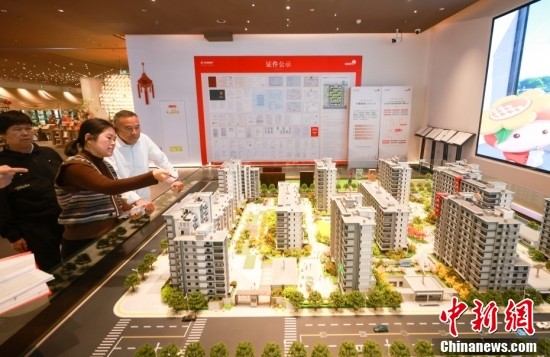 Citizens looking over commercial apartments inside a property sales center in Beijing. (Photo: China News Service/Jia Tianyong)