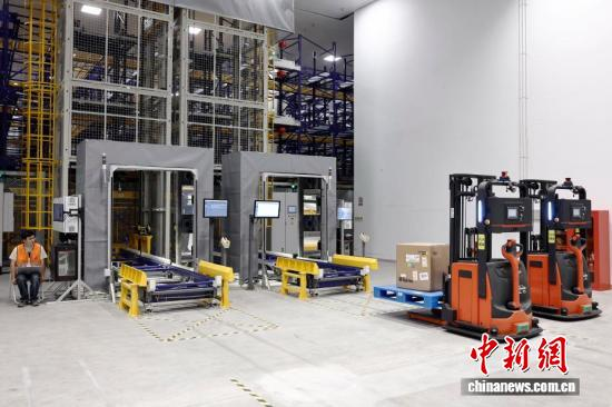 A stuff member monitors the operation of automated forklifts at Shanghai Pudong International Airport. (Photo: China News Service/Yin Liqin)