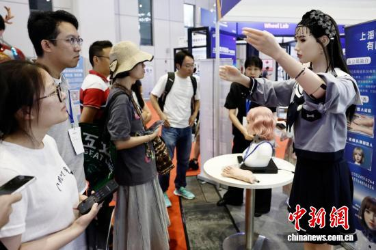 Visitors interact with humanoid robots at the 2026 Shanghai International Embodied Intelligence Industry Expo on July 2, 2026. (Photo: China News Service/Yin Liqin)