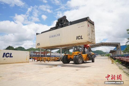 Workers unload refrigerated containers from a freight train at Pingxiang Railway Station, Guangxi, July 10, 2026. (Photo: China News Service/Lin Yingying)