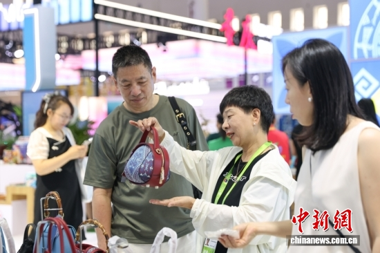 A merchant introduces intangible cultural heritage goods to customers at the 6th China International Consumer Products Expo in Haikou, Hainan, April 17, 2026. (Photo: China News Service/Yang Yuran)