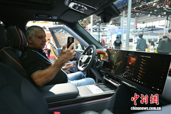 The interior of a Chinese-made smart vehicle attracts a foreign visitor at the 4th China International Supply Chain Expo in Beijing, June 23. (Photo: China News Service/Zhao Wenyu)