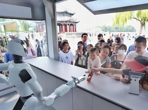 A robot delivers an item to a tourist at a robot retail store in Beijing. (Photo/China News Service)