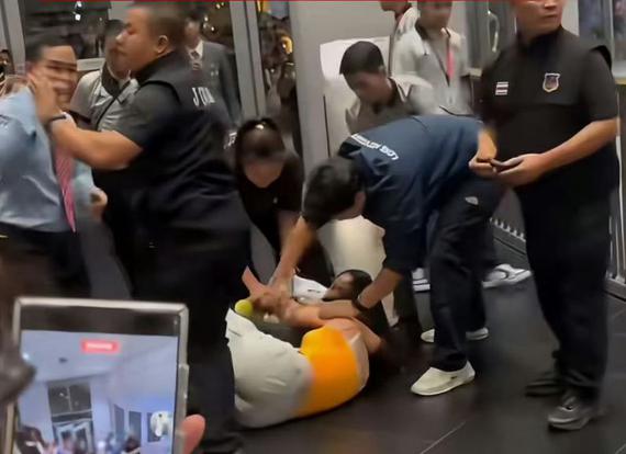 A Chinese fan is forcibly restrained by staff during a Thai entertainment company GMMTV fan event in Bangkok, July 25, 2026. (Screenshot from online video)