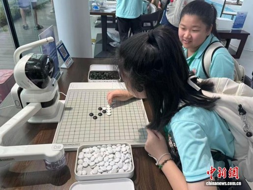 Students play chess game with a robot, July 28, 2026. (Photo: China News Service/ Xuan Jinwan)
