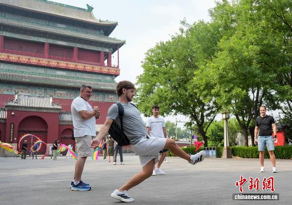A foreign tourist plays shuttlecock in the Zhongguglou Square in Beijing, July 27, 2026. (Photo: China News Service)