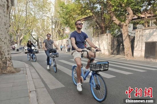 Foreign tourists ride shared bikes in Shanghai. (Photo: China News Service)