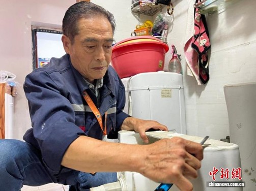 A “property service supermarket” worker replaces a faucet for a resident. (Photo: China News Service/ Lyu Shengnan)
