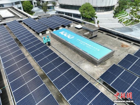Two power workers carry out final checks on solar panels at the 1,038‑-kW distributed PV project at Ningbo Science High School, August 12, 2026. (Photo: China News Service/ Qi Chunchun)