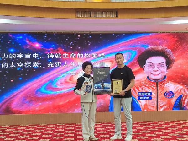 Huang Xiaochi, 73, holds ticket No. 022 for a suborbital space tourism flight in Foshan, Guangdong Province, on Aug. 8, 2026. (Photo: Nanfang Plus/Ouyang Shaowei)