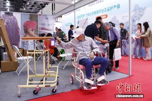 An elderly resident tests walking aids, wheelchairs and other assistive devices at the 12th China International Senior Services Expo in Beijing on May 18, 2026. (Photo: China News Service/Wang Ziru)