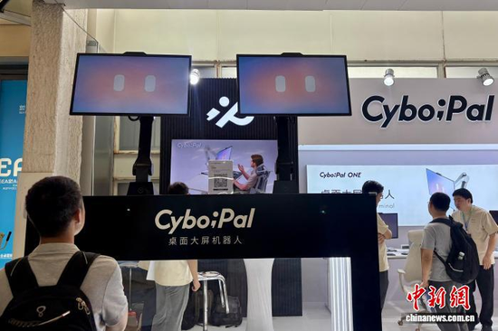 Visitors view the “CyboPal” desktop robot at the exhibition, August 19, 2026. (Photo: China News Service/ Xu Jing)